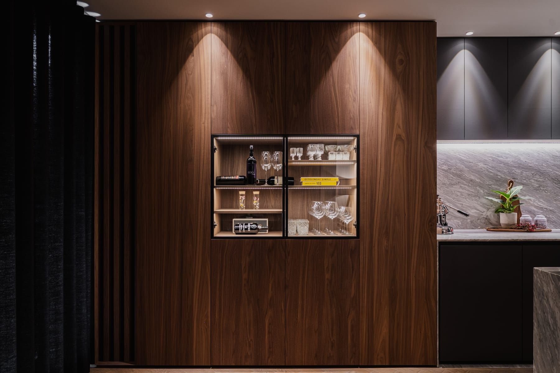 Walnut cabinet wall with lit glass display niche in Churchlane
