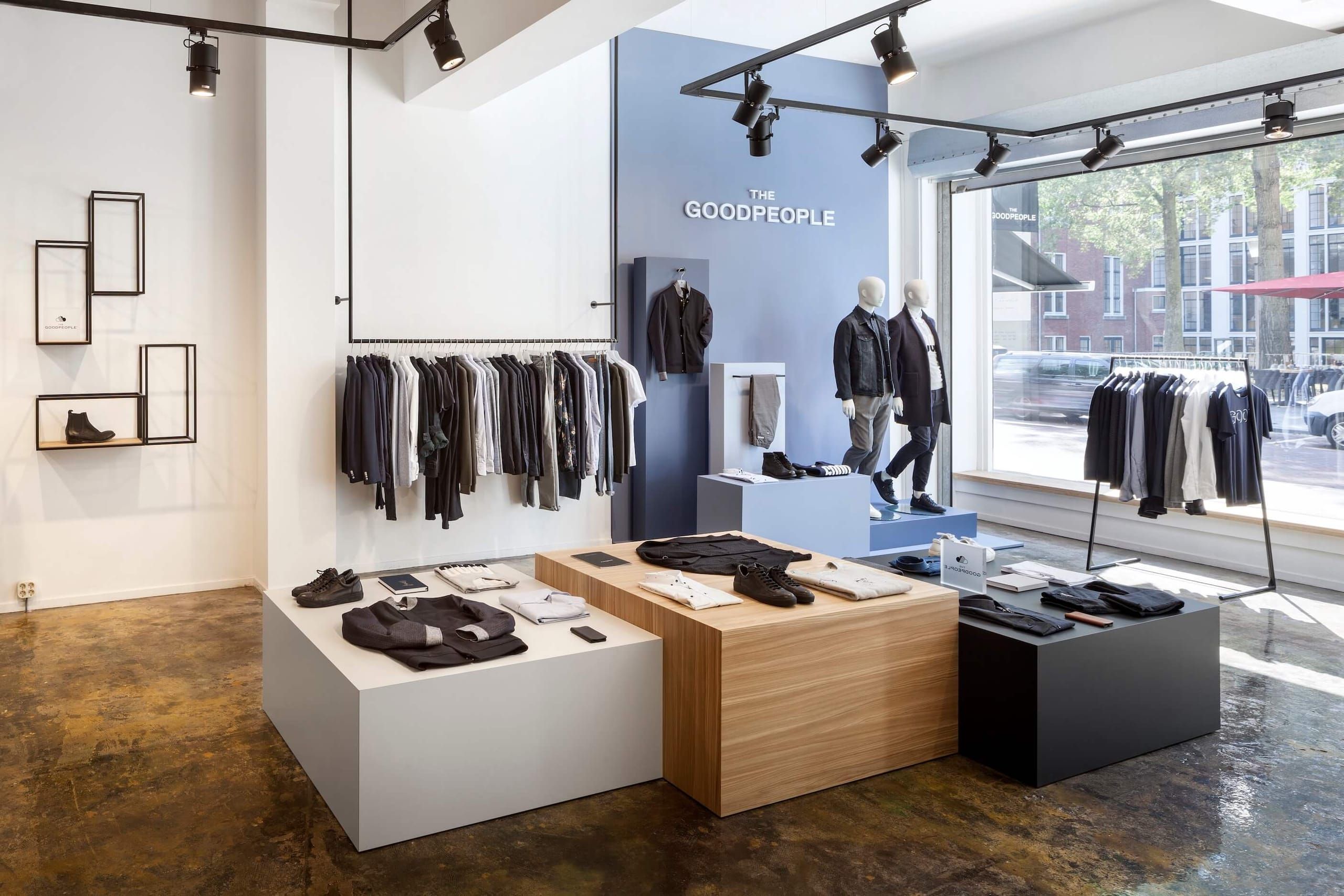 Blue feature wall with mannequins and display plinths beside a shop window
