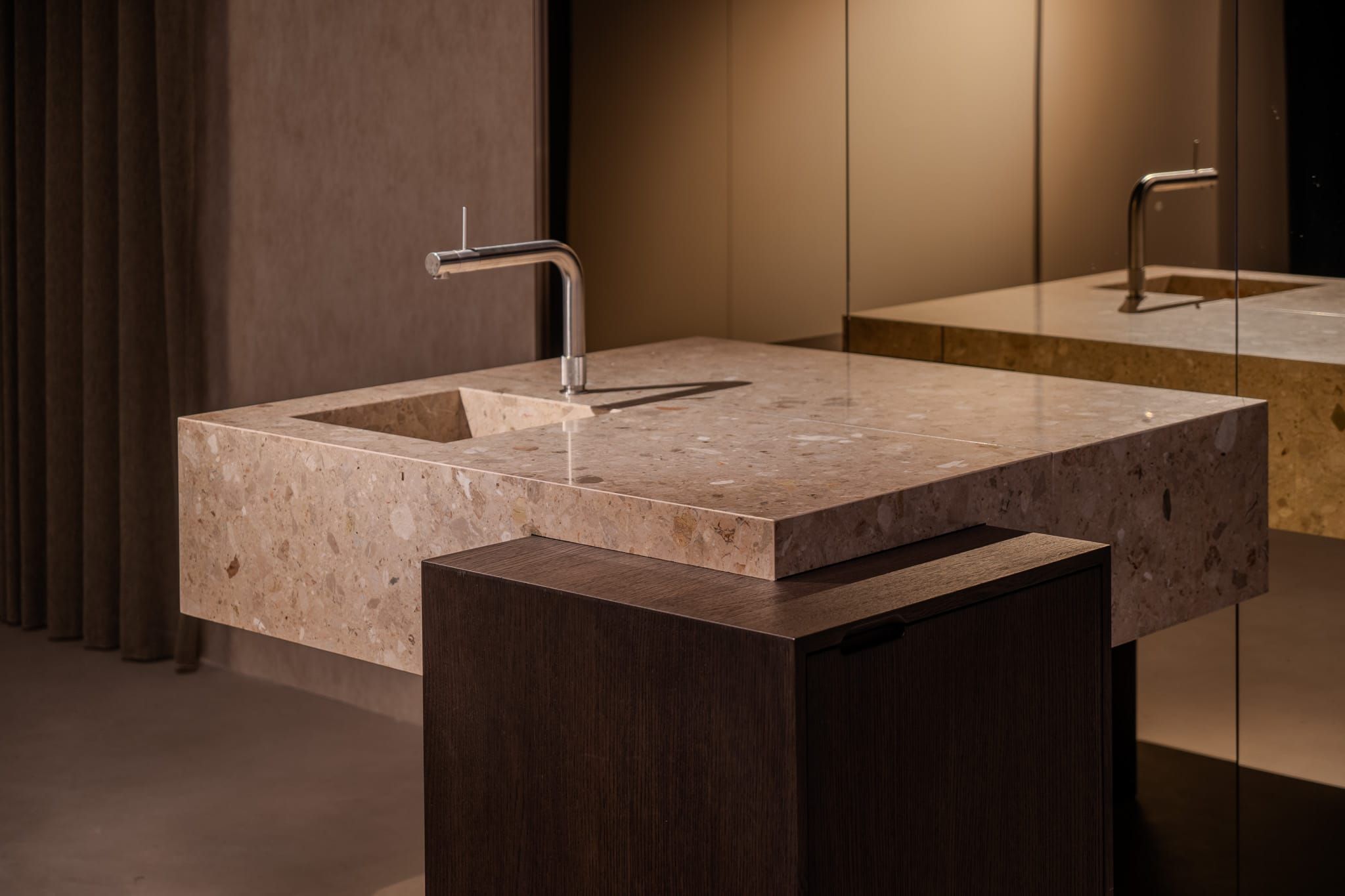 Terrazzo washbasin with chrome tap on a dark oak base in the TDG office