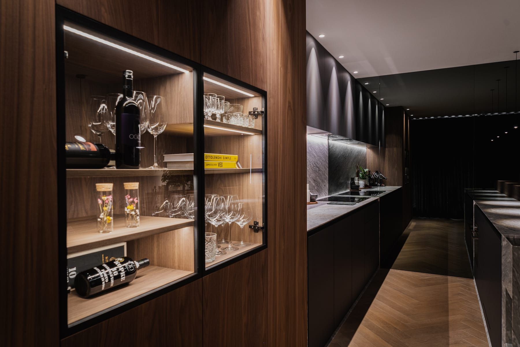 Lit glass display niche in walnut, looking along the kitchen