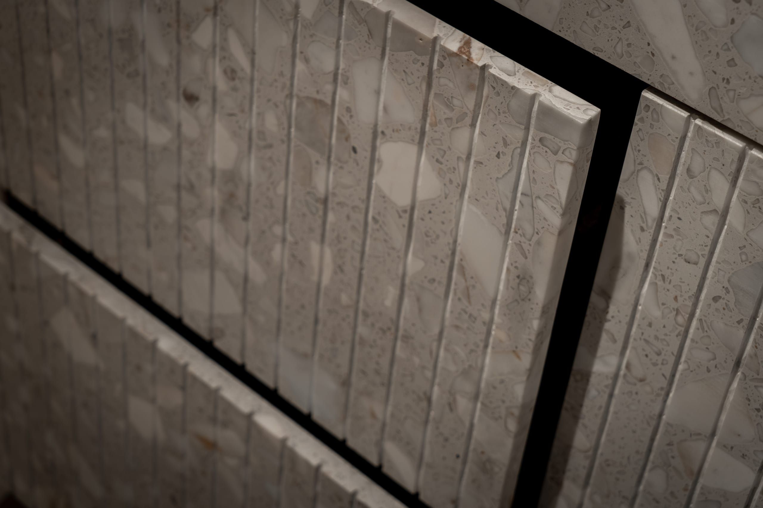 Fluted terrazzo drawer fronts set in a black frame