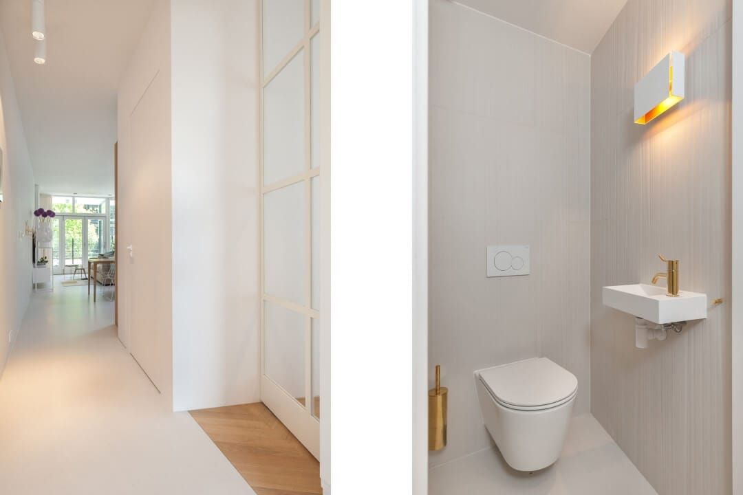 Hallway with glazed door next to a cloakroom with brass tap and wall light