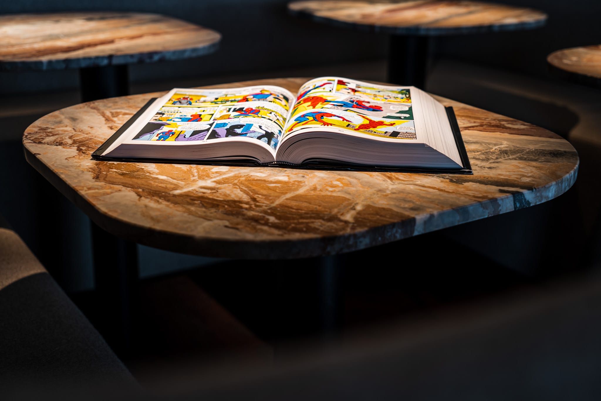 Open comic book on a rounded marble side table