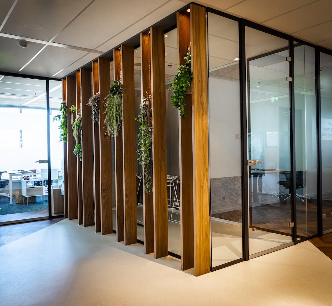 Vertical timber fins with trailing plants beside glass meeting rooms