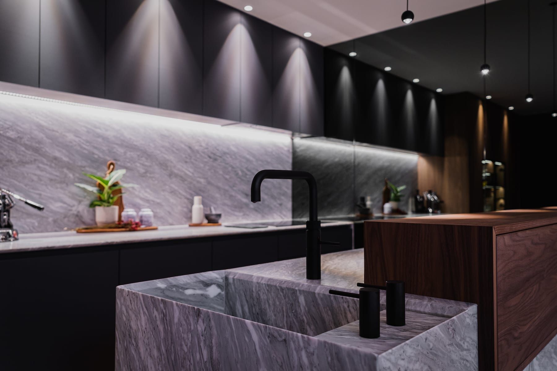 Black tap on the marble island sink beside a walnut bar front