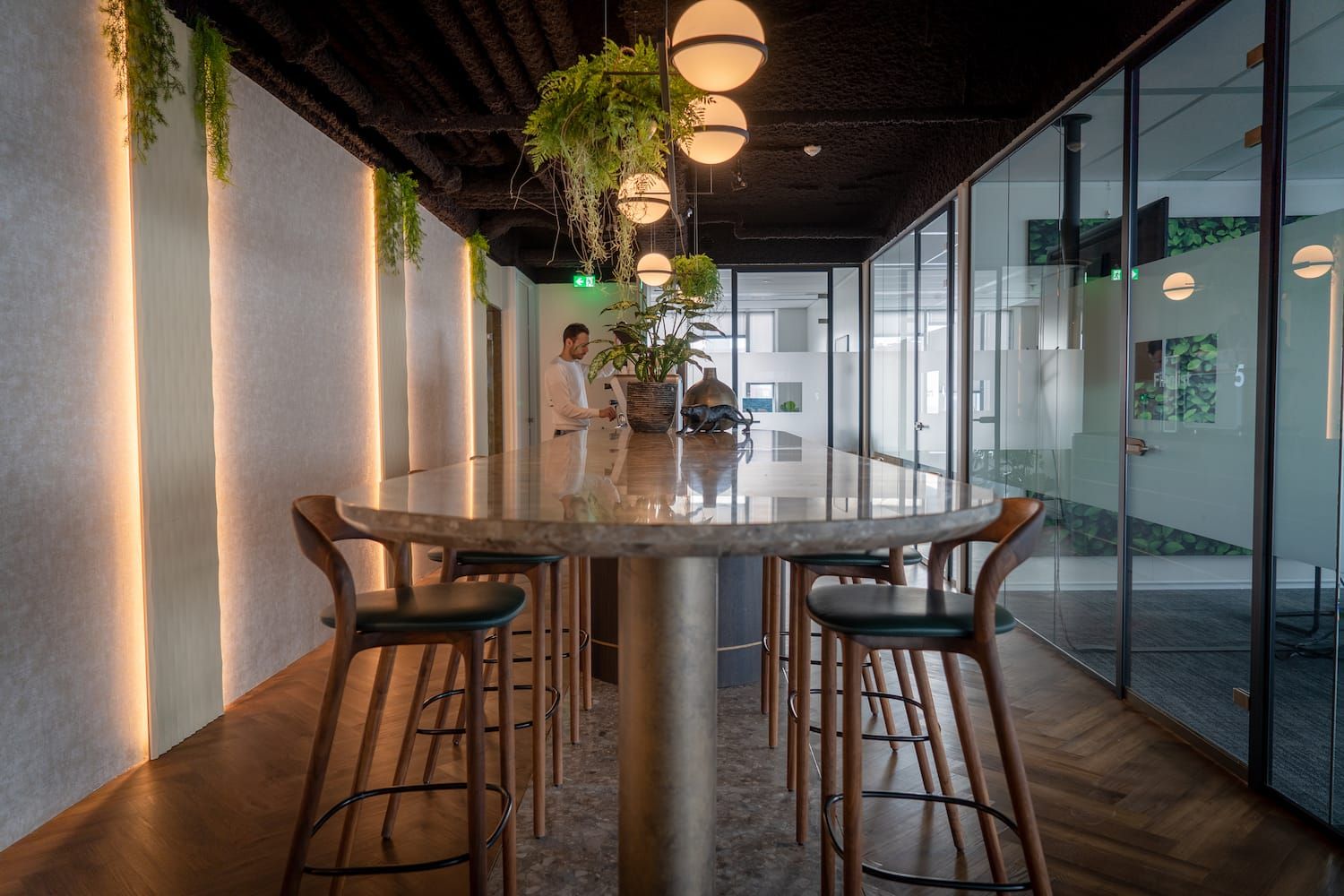 Office with a high stone table, bar stools and globe pendants
