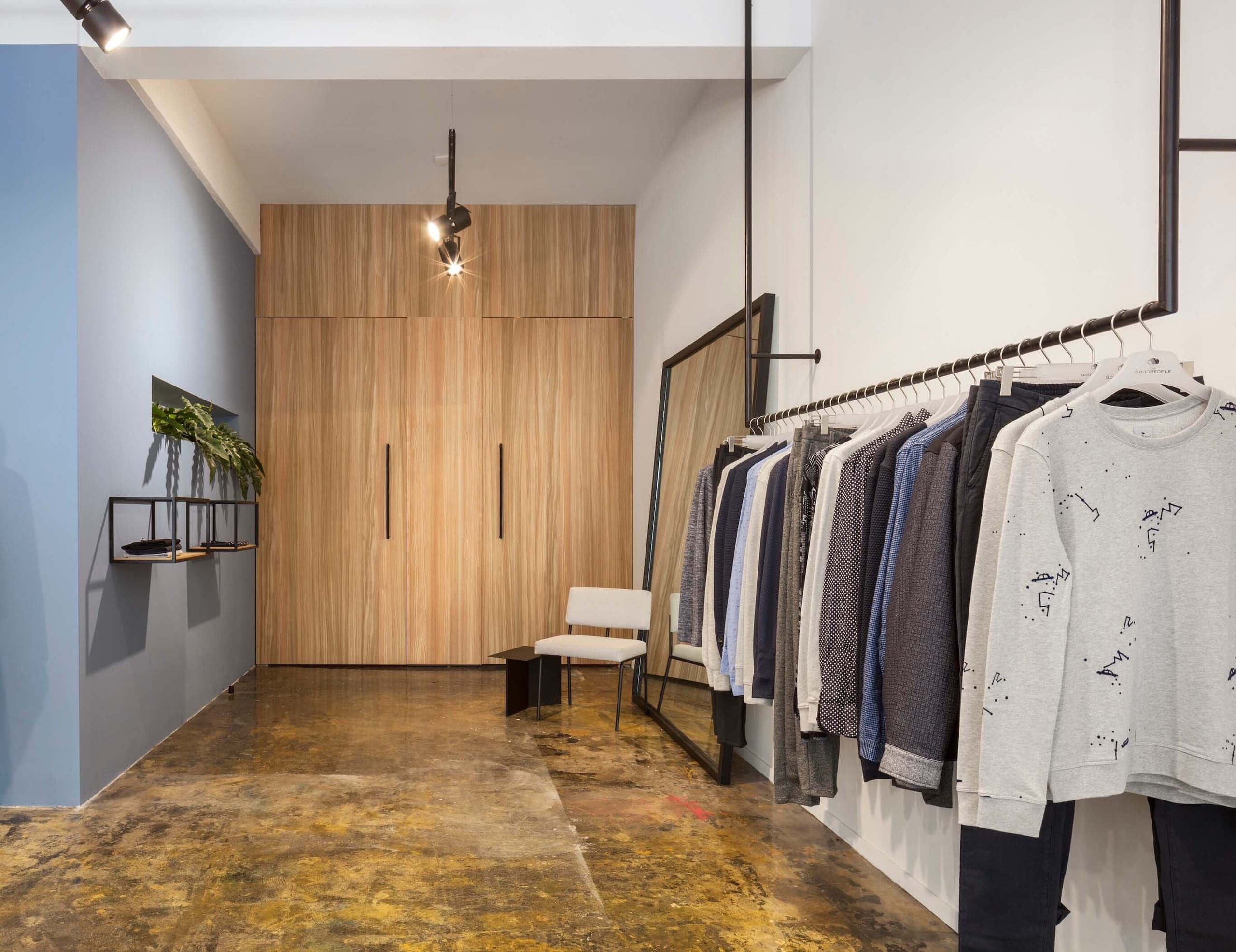 Fitting corner with oak wardrobes, a white chair and a blue wall with a plant shelf