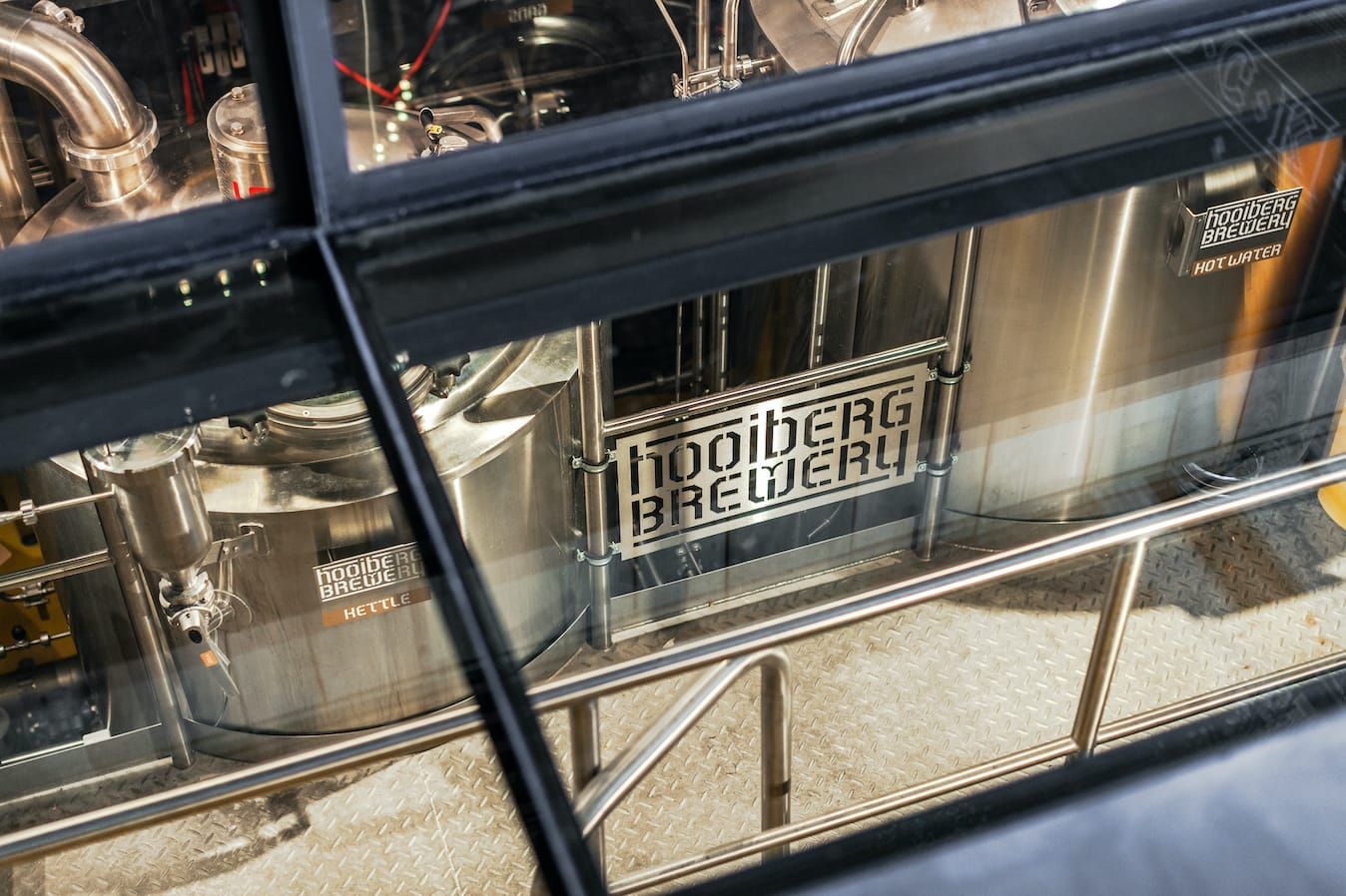 Brewing tanks seen through glass panes in the brewery