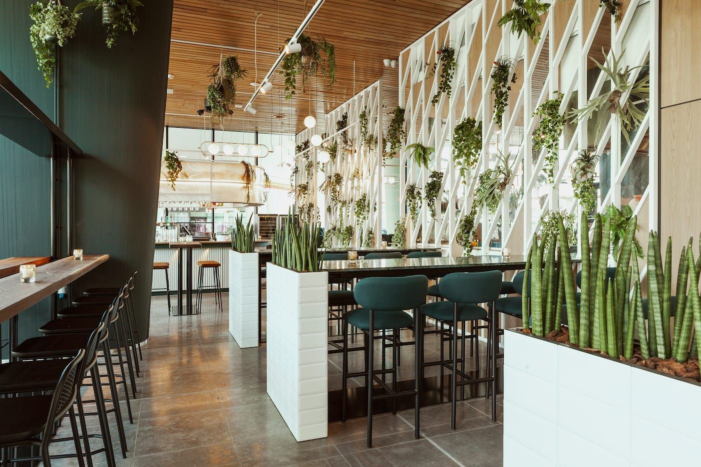 Black stools, white planters and the lattice screen along the restaurant floor