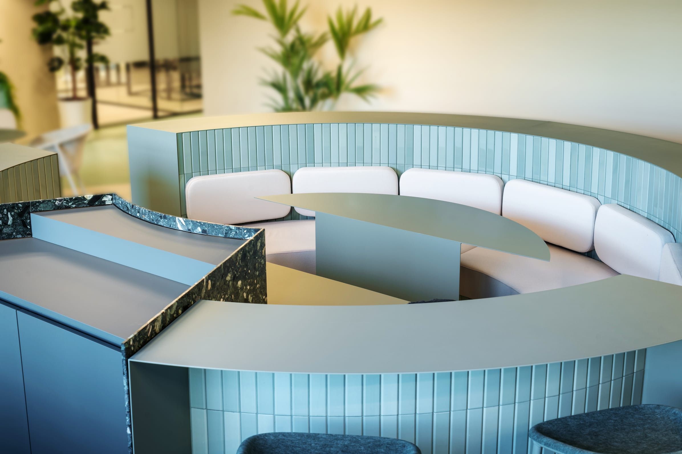 Overhead view of a circular tiled seating booth with terrazzo and green counters