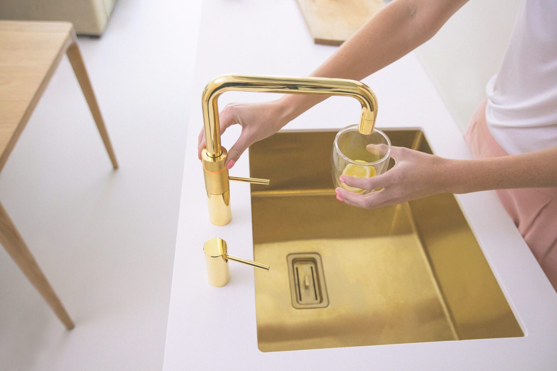 Brass tap and brass sink in a white worktop in the Sunshine kitchen