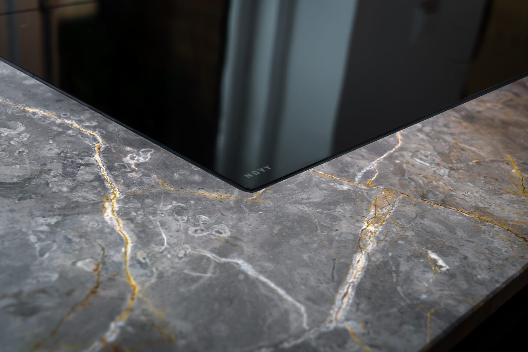 Induction hob set into a veined grey stone worktop