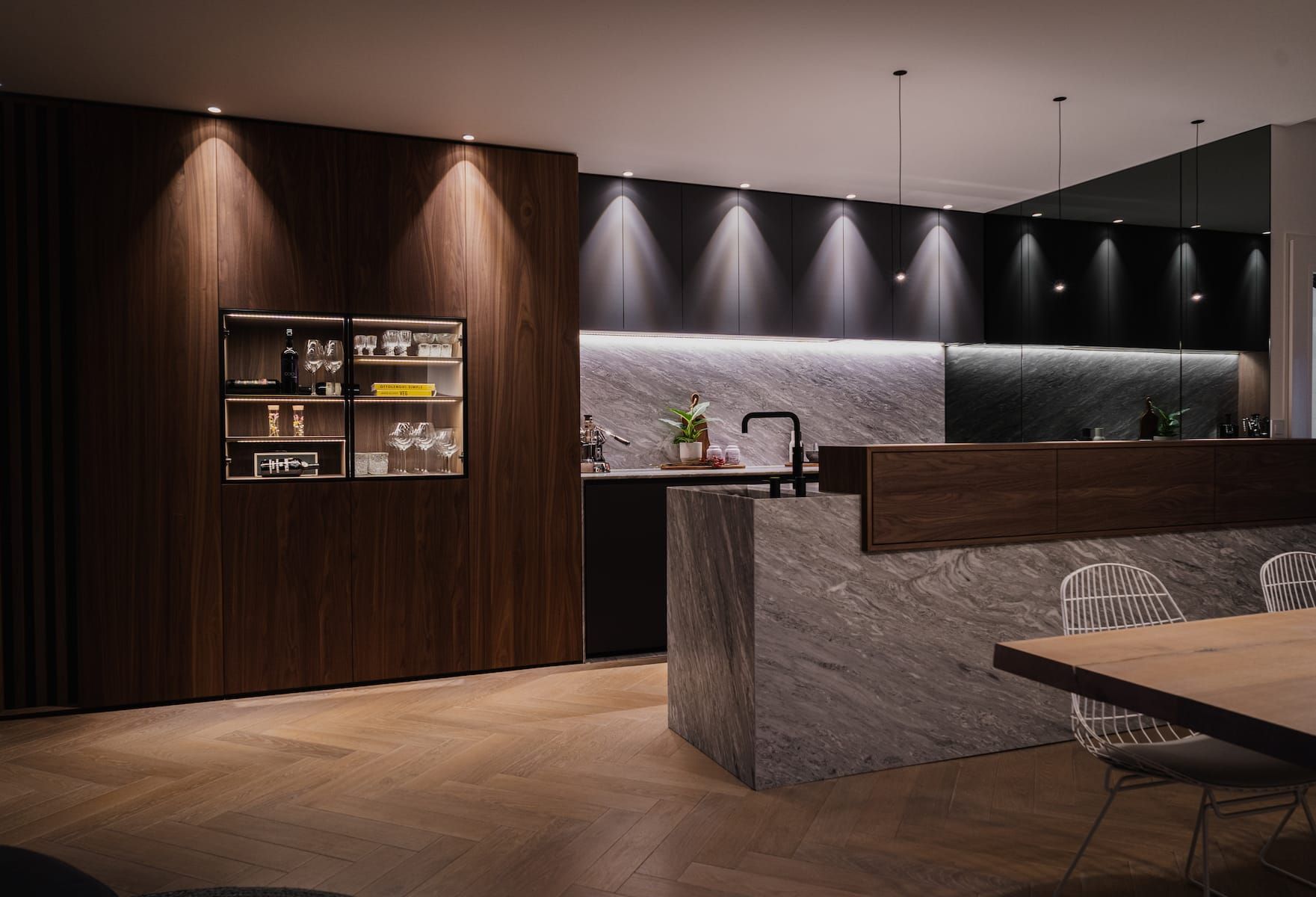 Dark wooden kitchen with a marble island and herringbone floor
